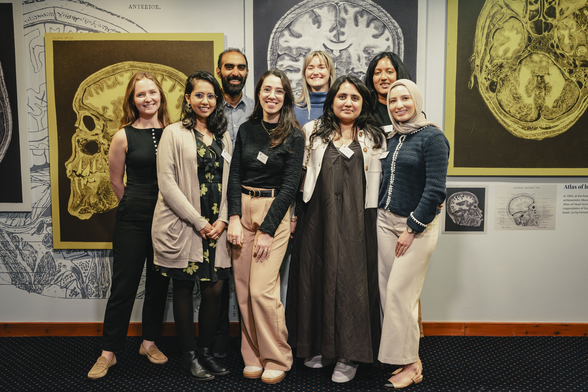 Group of delegates posing in front of exhibition on Macewen